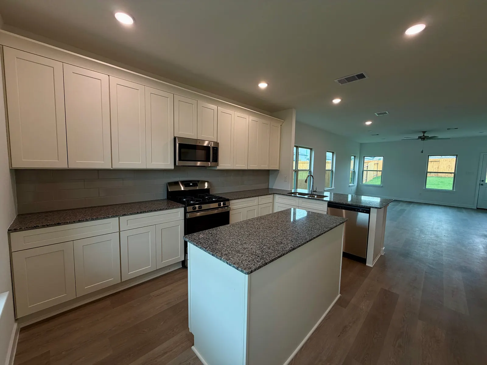 Kitchen island open to the living area at 11830 Serena's Song Drive, Willis, TX