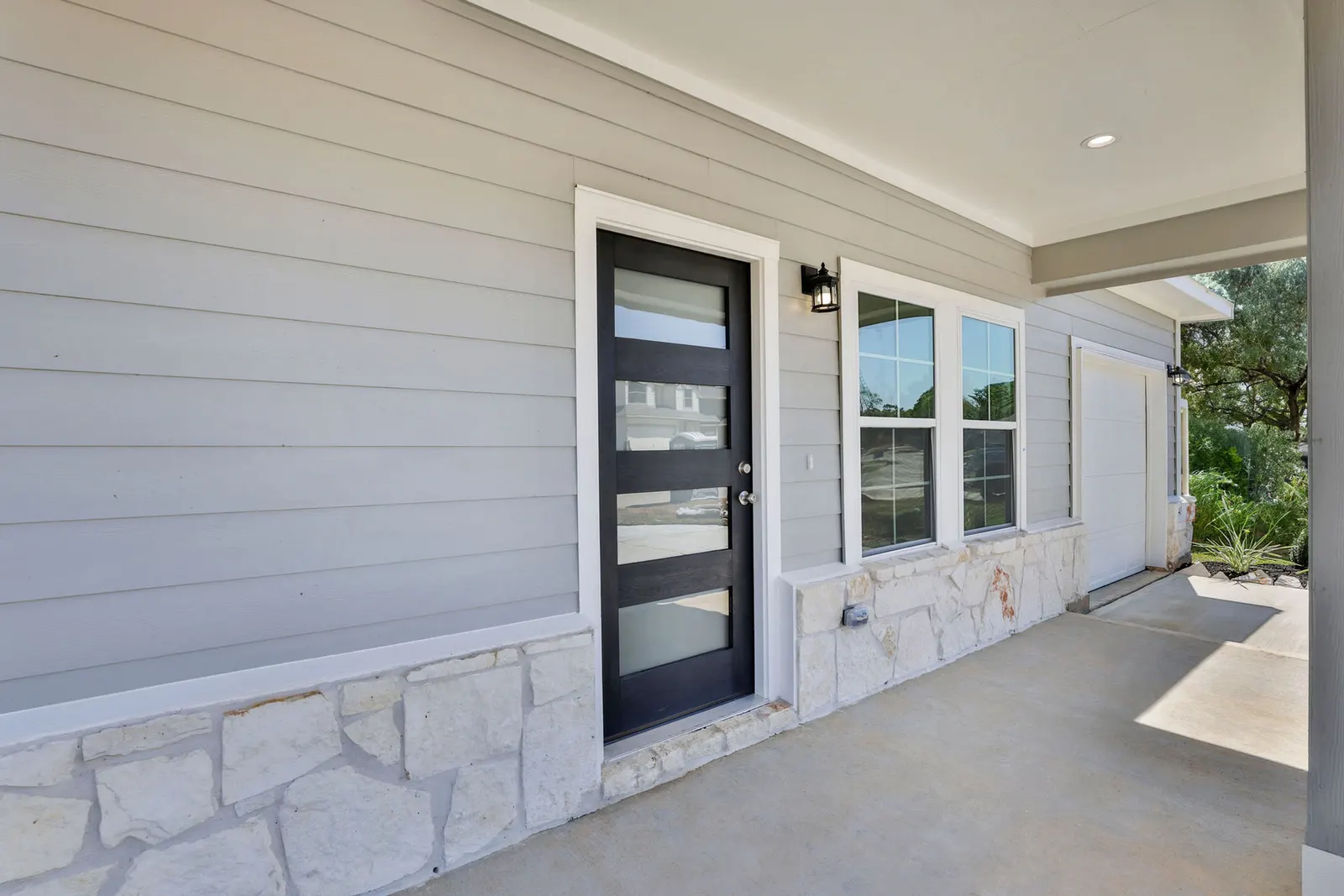 Covered front porch with stone accent at Lake Conroe Village, Montgomery, TX