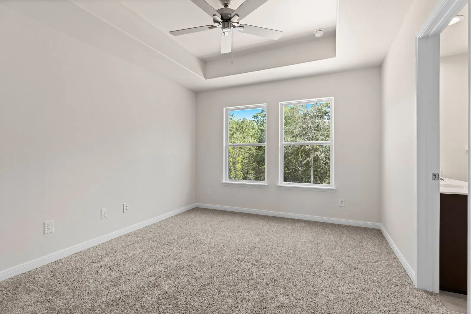 Carpeted bedroom with window at Lake Conroe Village, Montgomery, TX
