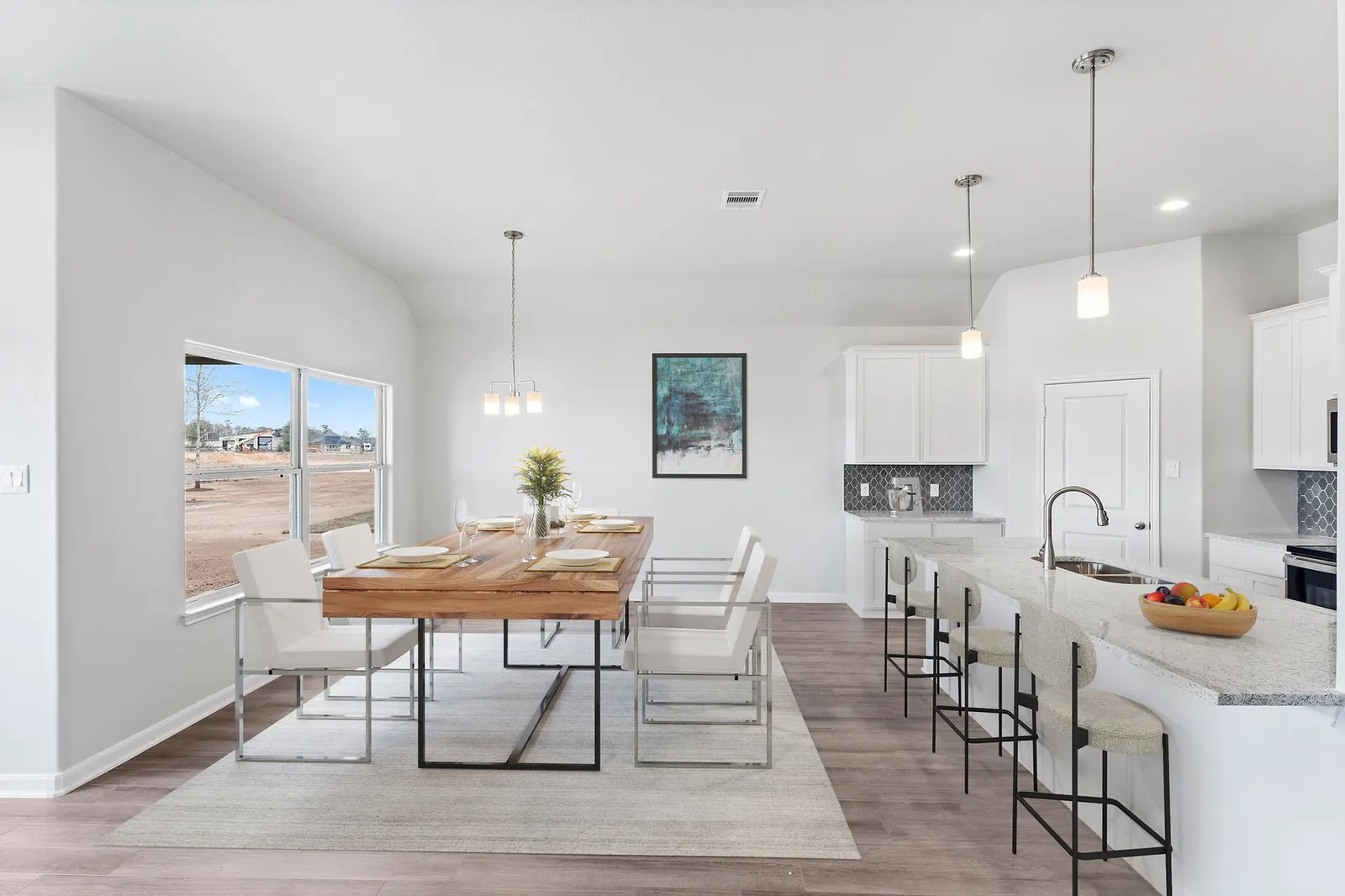 Dining area beside the kitchen island in an Alta home, with a window onto the neighborhood