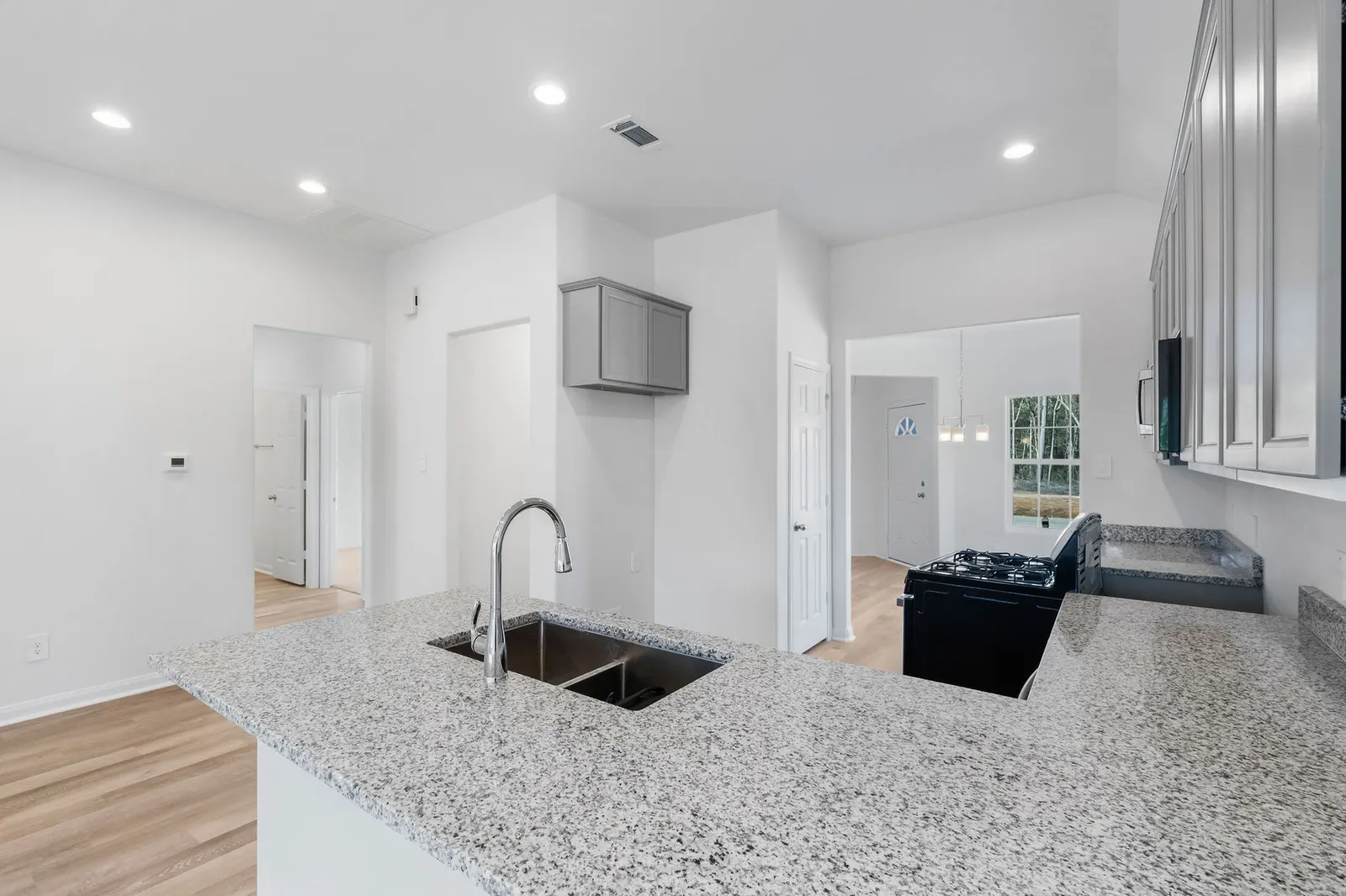 Kitchen with granite peninsula and sink at Cedar Crossing by Alta Homes