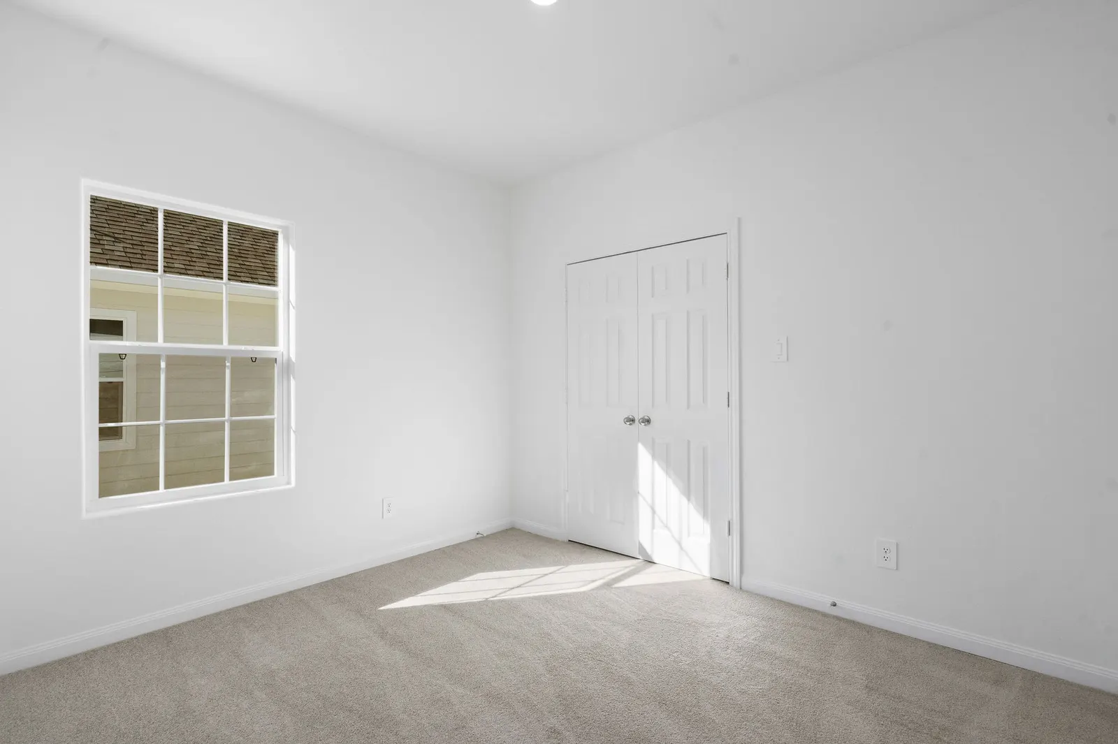 Carpeted bedroom with window and closet at Cedar Crossing by Alta Homes