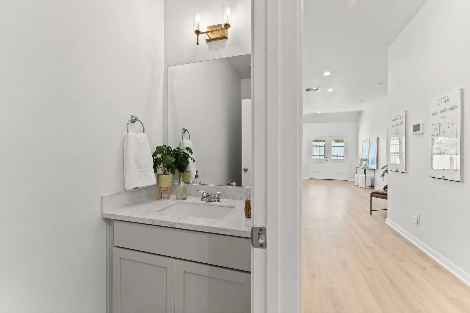 Powder room in an Alta home, with a quartz topped vanity and a framed mirror