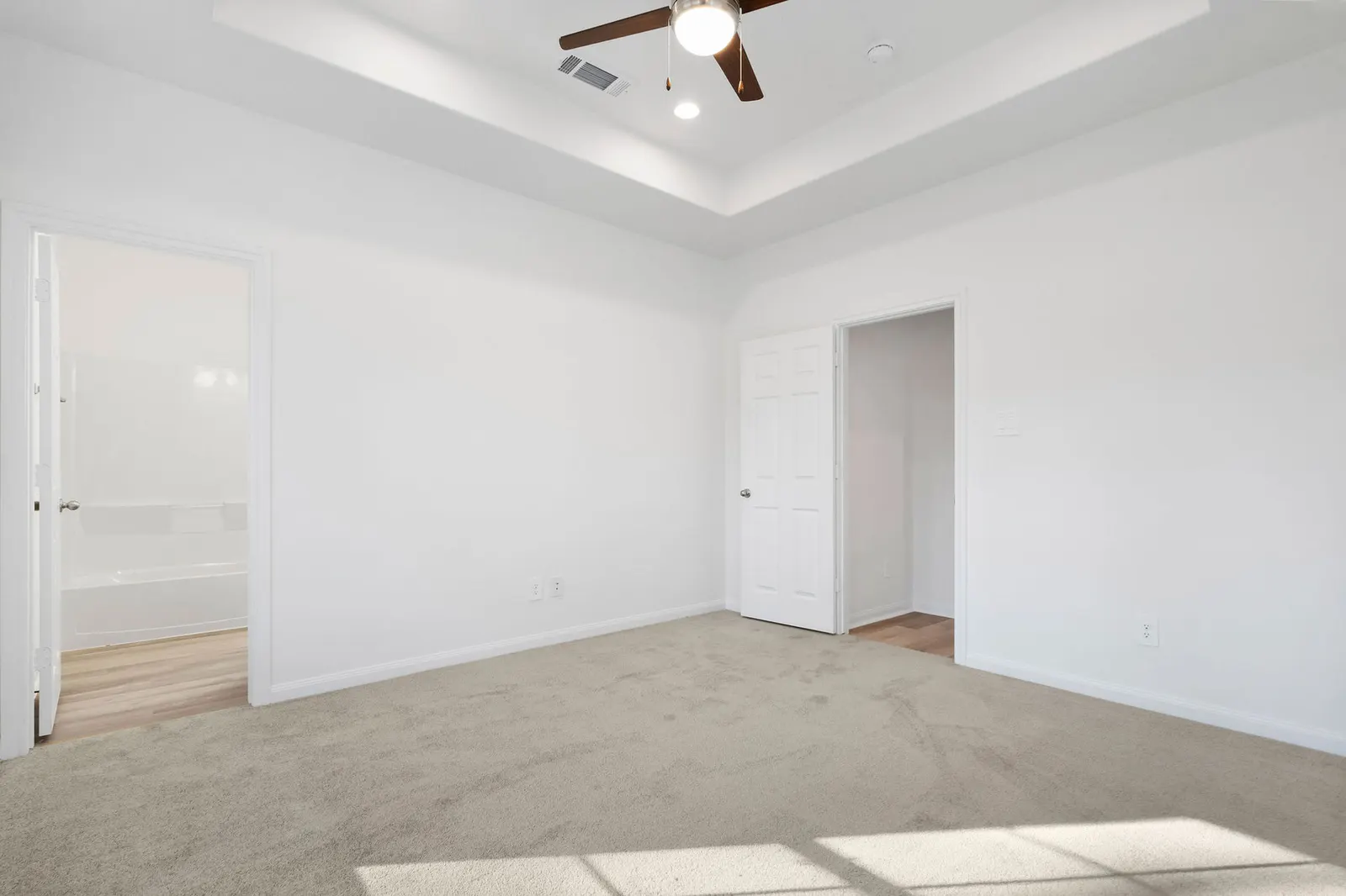 Living and dining area with tray ceiling at Cedar Crossing by Alta Homes